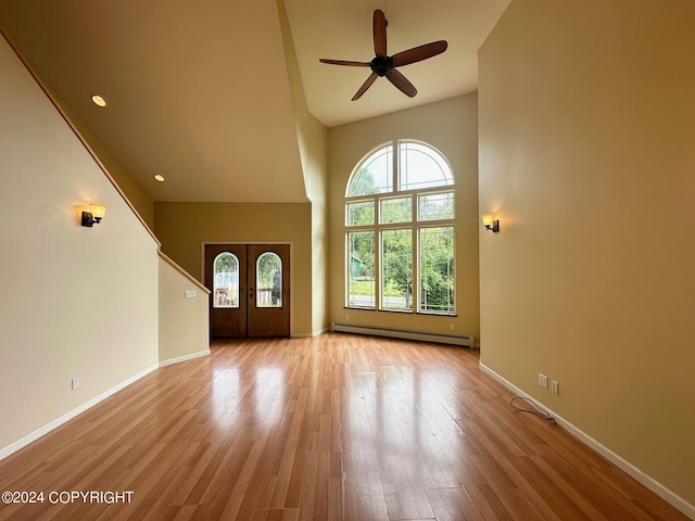 interior space with french doors, light hardwood / wood-style floors, baseboard heating, and ceiling fan