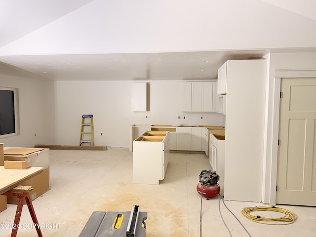 kitchen featuring white cabinetry and vaulted ceiling