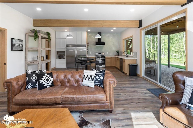 living room with beam ceiling, light wood-type flooring, and sink