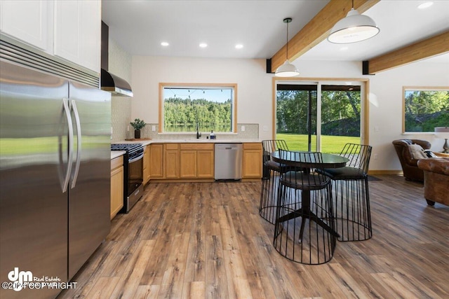 kitchen featuring sink, decorative light fixtures, beam ceiling, dark hardwood / wood-style flooring, and stainless steel appliances