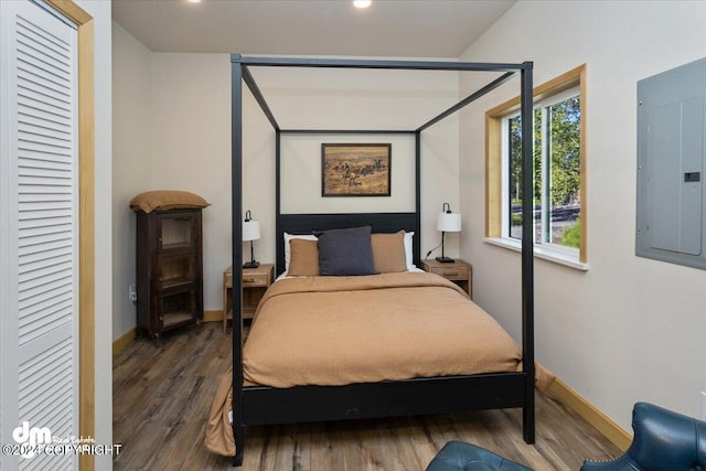 bedroom featuring electric panel and dark hardwood / wood-style floors