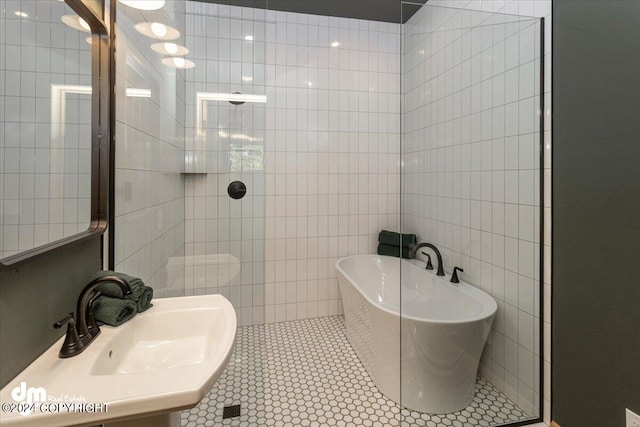 bathroom featuring tile patterned flooring, a washtub, and sink