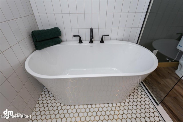 bathroom featuring a bathing tub, tile walls, and tile patterned floors