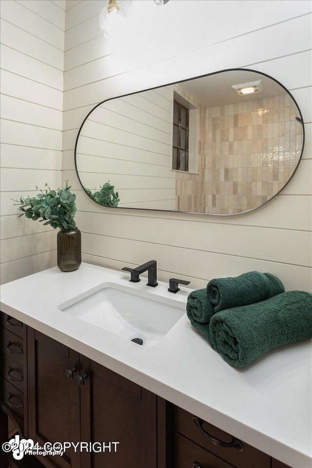 bathroom featuring vanity and wood walls