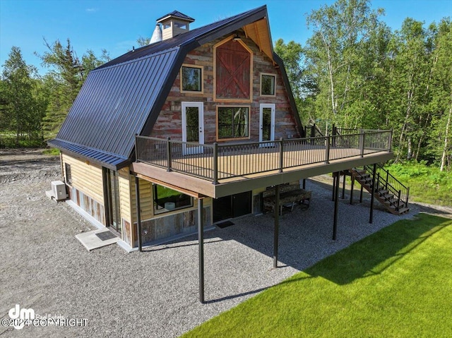 rear view of property with a deck, a patio, and a yard