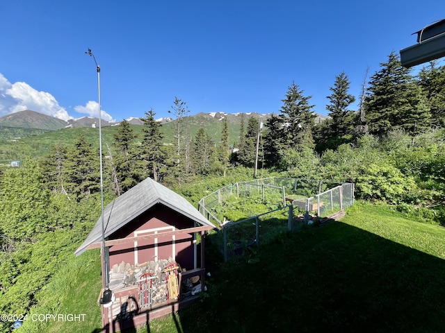 17041 Jacqueline Cir, Anchorage, AK 99516 - view of green lawn with a mountain view, a view of trees, and an outdoor structure
