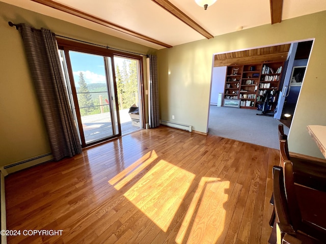 17041 Jacqueline Cir, Anchorage, AK 99516 - empty room featuring a baseboard heating unit, beamed ceiling, a baseboard radiator, wood finished floors, and baseboards