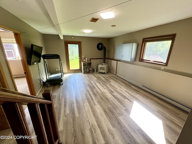 17041 Jacqueline Cir, Anchorage, AK 99516 - exercise room with a wood stove, wood finished floors, a baseboard radiator, and baseboards