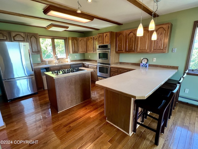 17041 Jacqueline Cir, Anchorage, AK 99516 - kitchen featuring stainless steel appliances, brown cabinets, dark wood finished floors, a center island, and a sink