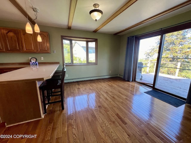 17041 Jacqueline Cir, Anchorage, AK 99516 - kitchen with a baseboard heating unit, a kitchen bar, a peninsula, beamed ceiling, and brown cabinets