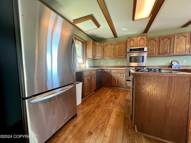 17041 Jacqueline Cir, Anchorage, AK 99516 - kitchen with appliances with stainless steel finishes, light wood-style floors, a sink, and brown cabinets