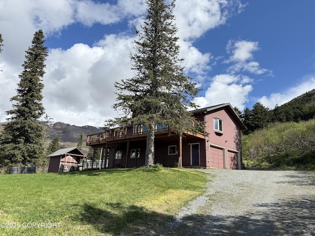 17041 Jacqueline Cir, Anchorage, AK 99516 - view of front facade with driveway, a garage, a deck with mountain view, and a front yard