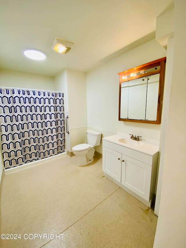 bathroom featuring vanity, toilet, and curtained shower