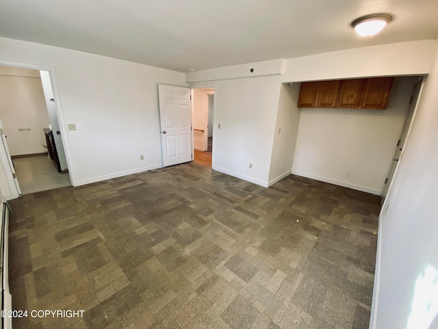 unfurnished bedroom featuring dark colored carpet