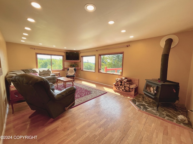 living room with light hardwood / wood-style flooring and a wood stove