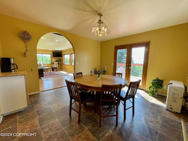 dining space with french doors and an inviting chandelier