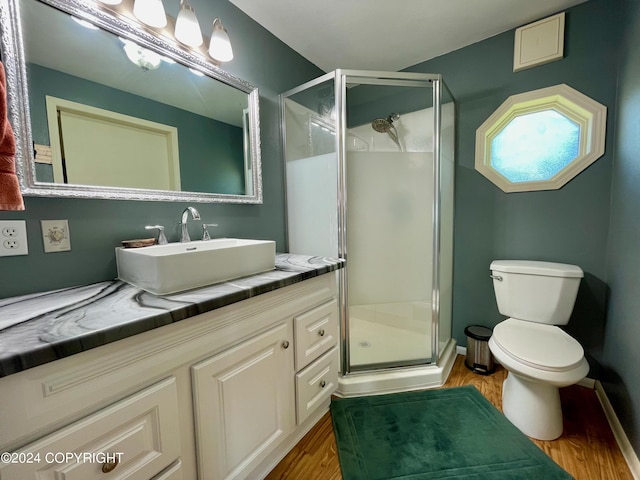 bathroom with vanity, walk in shower, toilet, and hardwood / wood-style flooring