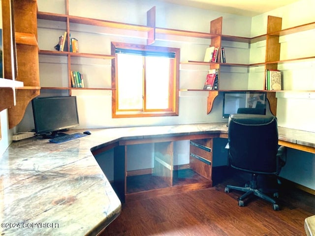 unfurnished office featuring built in desk and dark hardwood / wood-style flooring