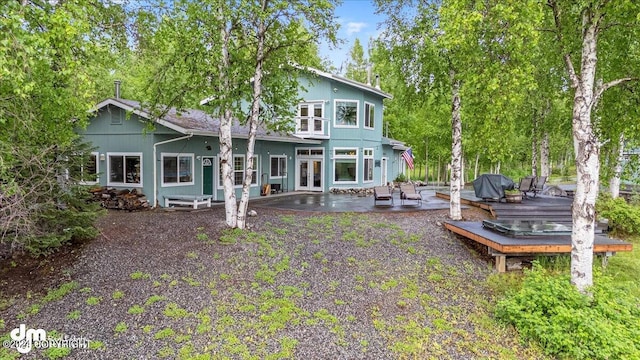 back of house featuring a deck and a patio area