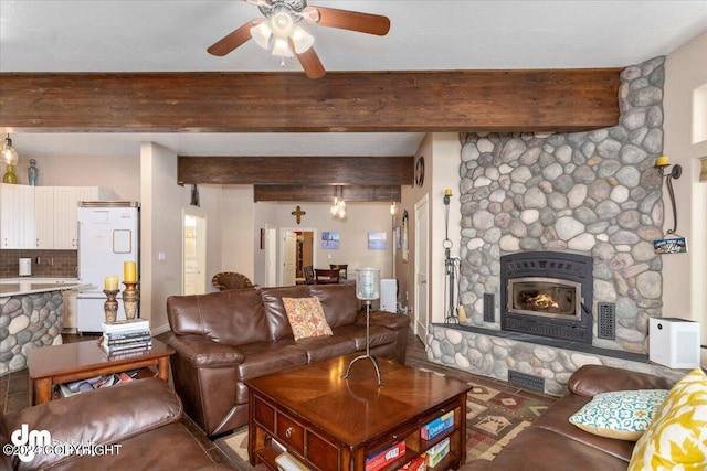 living room with beamed ceiling, ceiling fan, and a fireplace