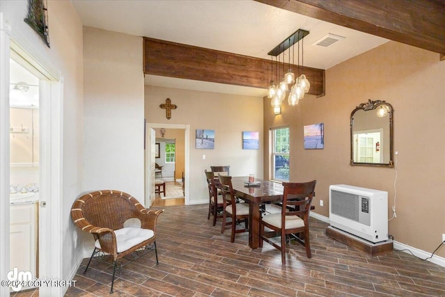 dining room with heating unit, a chandelier, and beamed ceiling