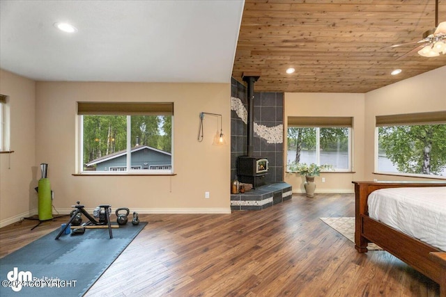 bedroom with a wood stove, hardwood / wood-style floors, and wood ceiling