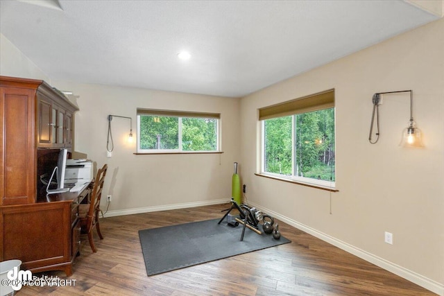 exercise room with dark wood-type flooring