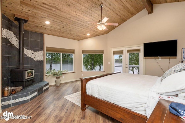 bedroom featuring a wood stove, dark hardwood / wood-style flooring, access to outside, wood ceiling, and beam ceiling