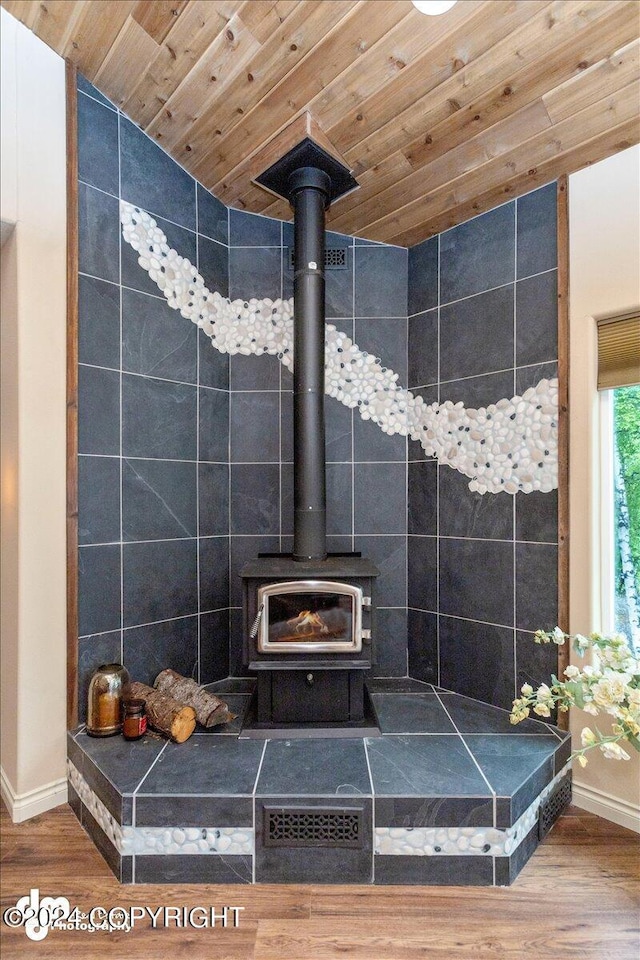 room details featuring hardwood / wood-style flooring, wooden ceiling, and a wood stove