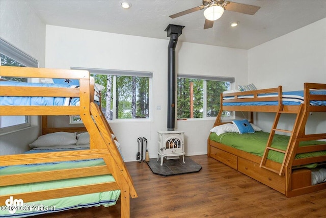 bedroom with dark hardwood / wood-style flooring and a wood stove