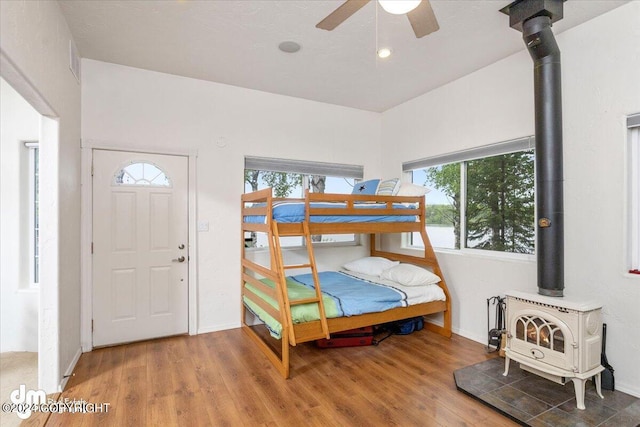 bedroom with hardwood / wood-style flooring and a wood stove