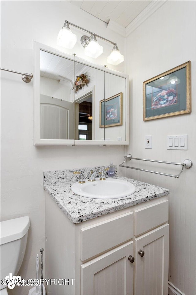 bathroom featuring vanity, ornamental molding, and toilet