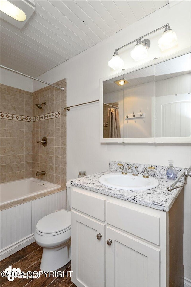 full bathroom with vanity, hardwood / wood-style floors, shower / bathtub combination with curtain, and toilet