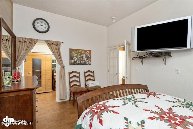 bedroom featuring hardwood / wood-style flooring and vaulted ceiling