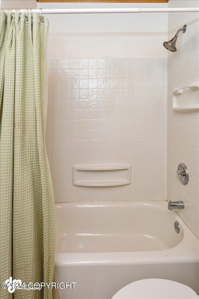 bathroom featuring shower / tub combo with curtain and toilet