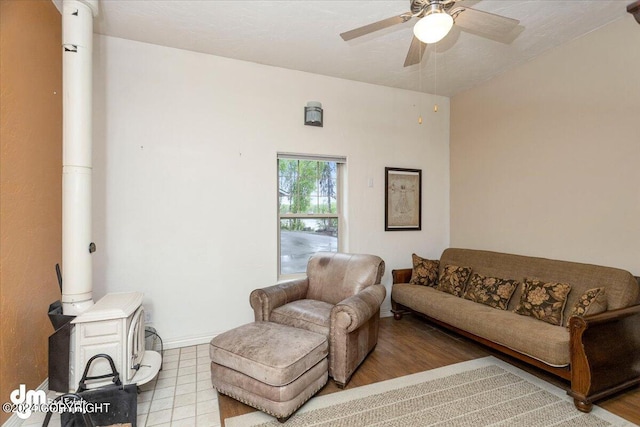 living room featuring a wood stove and ceiling fan