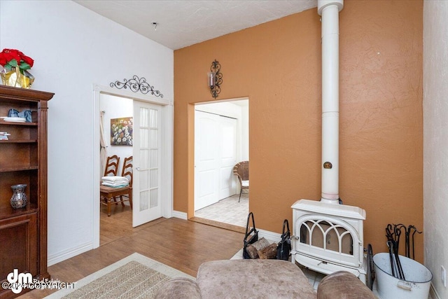 living area featuring hardwood / wood-style flooring, french doors, and a wood stove