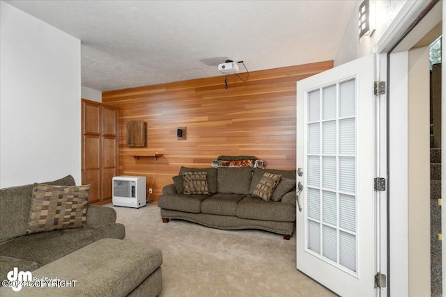 carpeted living room featuring a textured ceiling and wooden walls