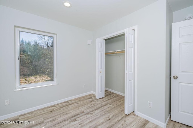 unfurnished bedroom featuring light wood-type flooring and a closet