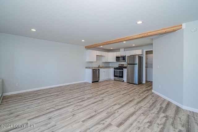 kitchen featuring appliances with stainless steel finishes, light hardwood / wood-style floors, white cabinets, and beam ceiling