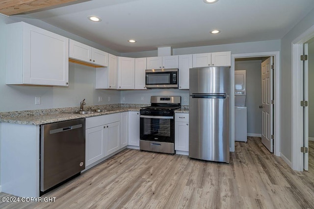 kitchen with stainless steel appliances, white cabinets, and sink