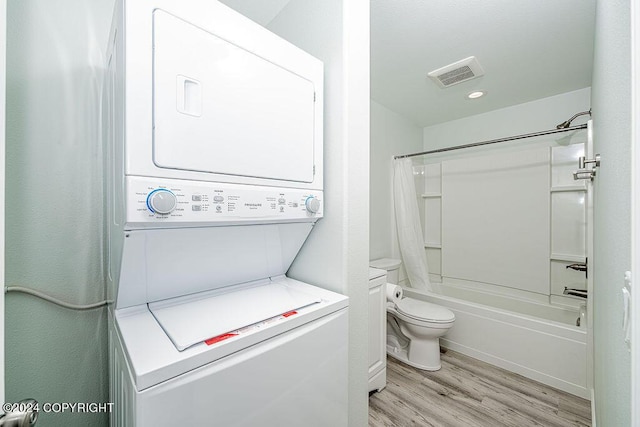 laundry area featuring light hardwood / wood-style flooring and stacked washer / dryer