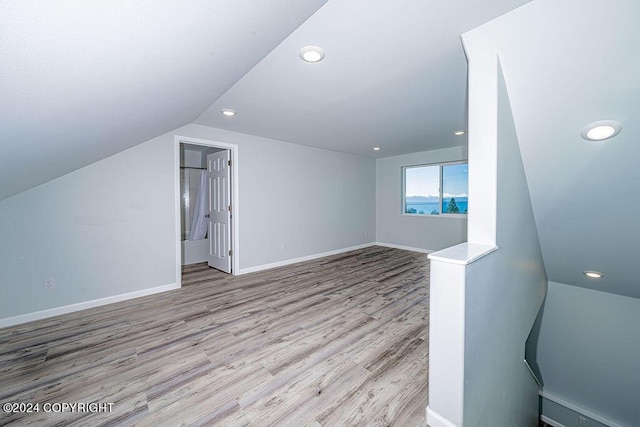 bonus room with vaulted ceiling and light hardwood / wood-style flooring