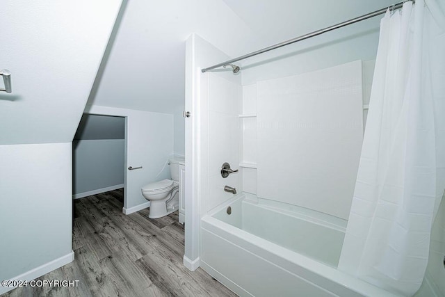 bathroom featuring toilet, vaulted ceiling, hardwood / wood-style floors, and shower / tub combo with curtain