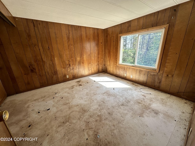 unfurnished room with wooden walls