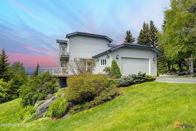 18706 Petrel Cir, Anchorage, AK 99516 - property exterior at dusk featuring a garage, concrete driveway, a yard, and a balcony