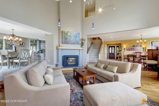 18706 Petrel Cir, Anchorage, AK 99516 - living area featuring a chandelier, a towering ceiling, wood finished floors, and a tiled fireplace