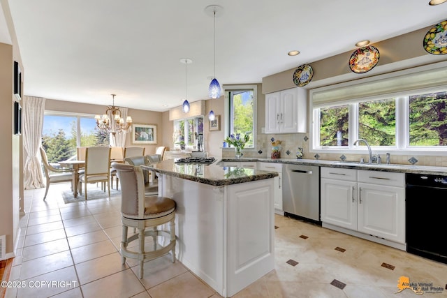 18706 Petrel Cir, Anchorage, AK 99516 - kitchen with stainless steel appliances, a sink, plenty of natural light, dark stone countertops, and recessed lighting