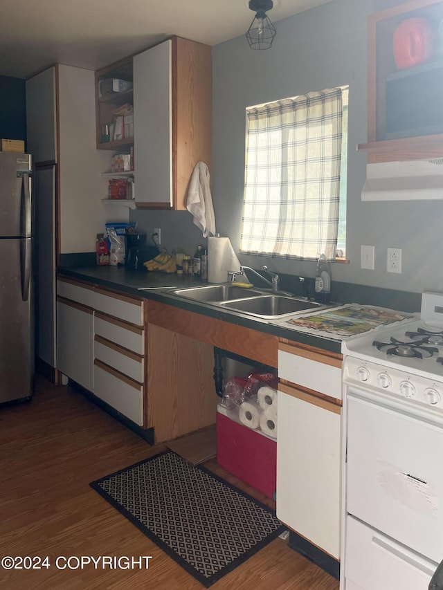 kitchen with white range oven, stainless steel fridge, dark hardwood / wood-style floors, and sink