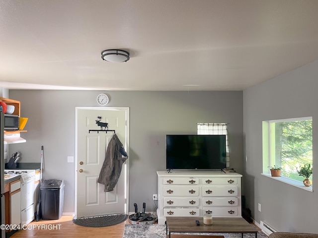 living room featuring light wood-type flooring and a baseboard heating unit